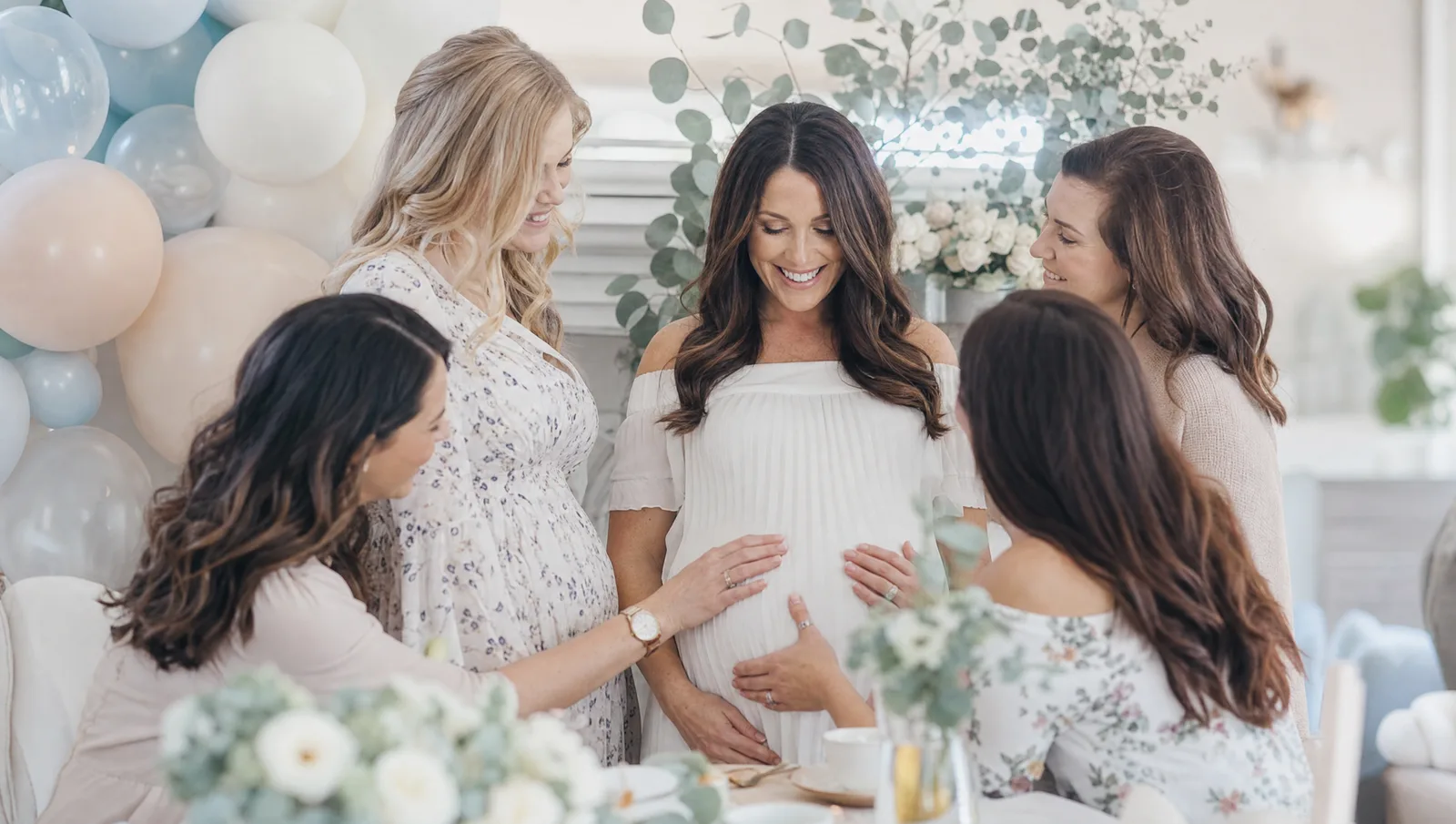 A glowing mother-to-be surrounded by friends at a baby shower
